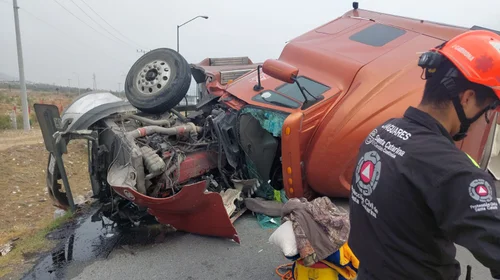 De acuerdo con los primeros reportes, el tráiler volcó debido al exceso de velocidad con el que fue tomada una curva en el acceso al cruce.
